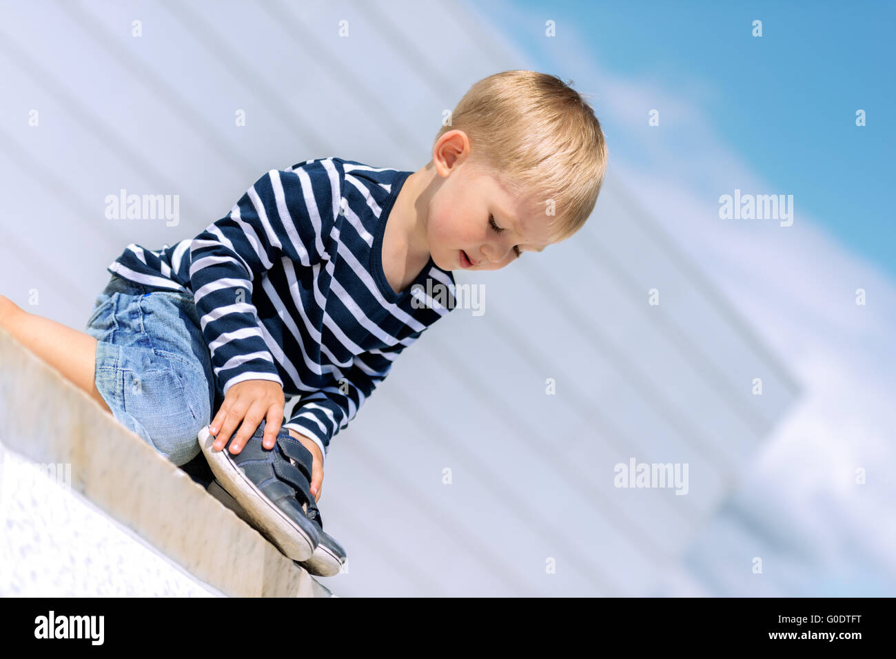 Portrait of little preschool boy outdoors with shoes Stock Photo