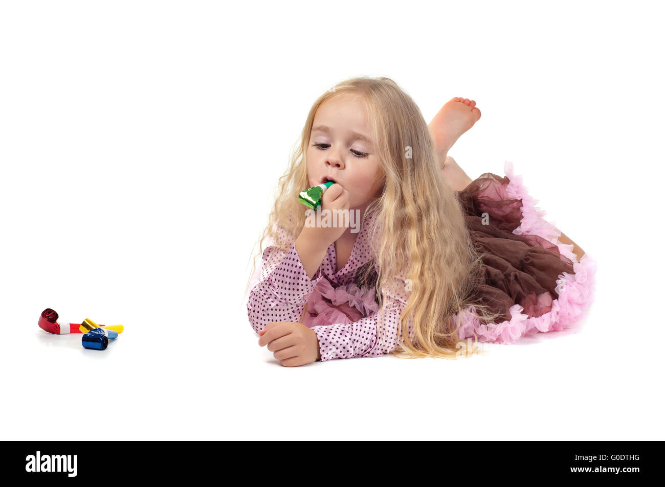Little baby girl in tutu skirt using party blower Stock Photo