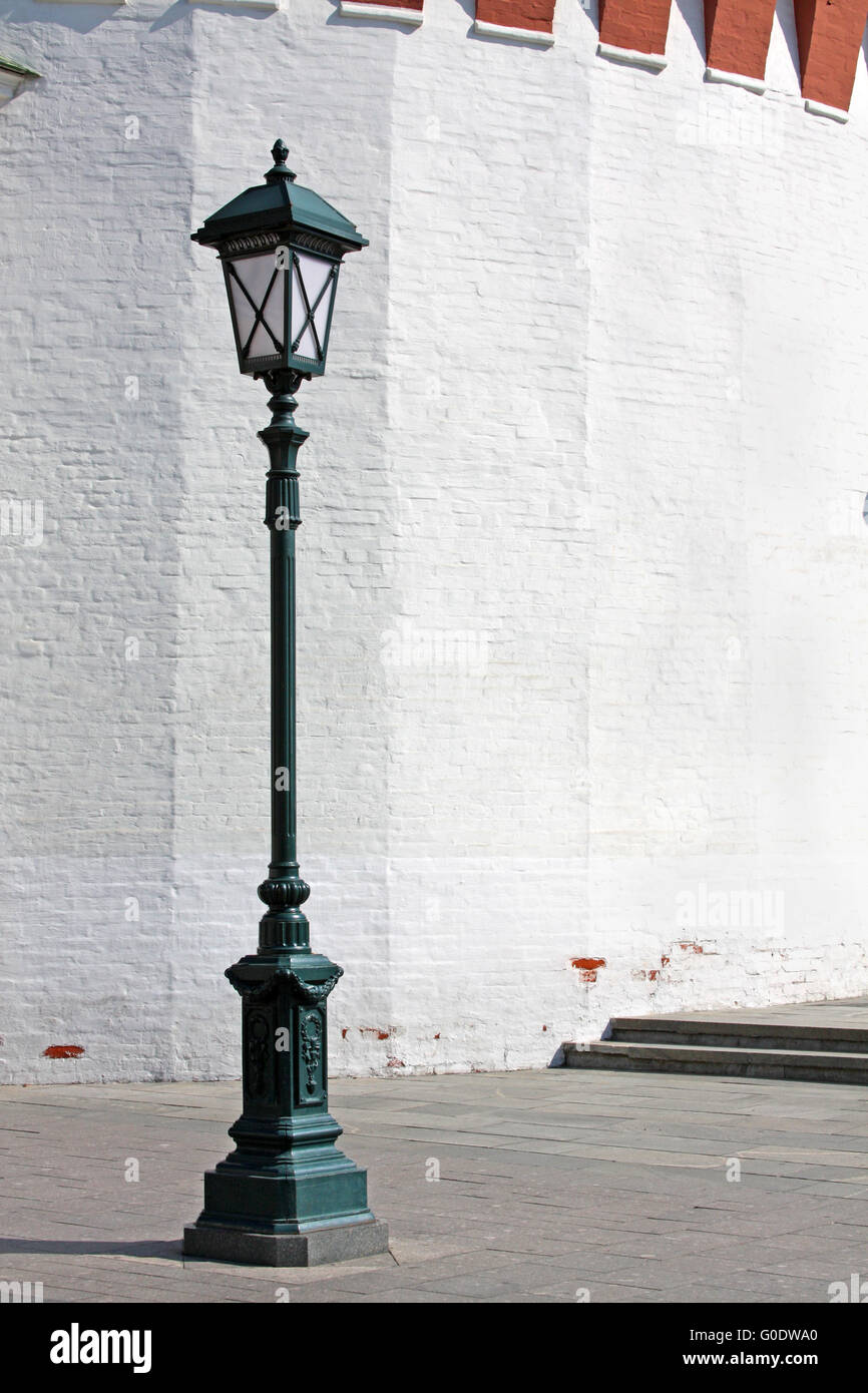 Old style street lamp in front of the wall of whit Stock Photo