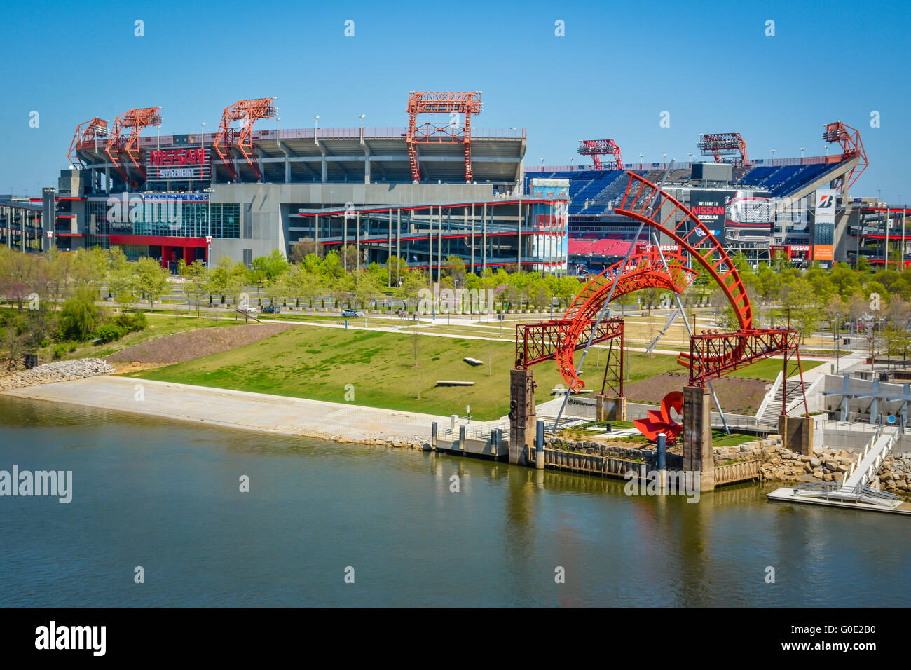 View across the Cumberland River in downtown Nashville TN towards the NFL team Titans' Nissan stadium with 'Ghost Ballet' art Stock Photo