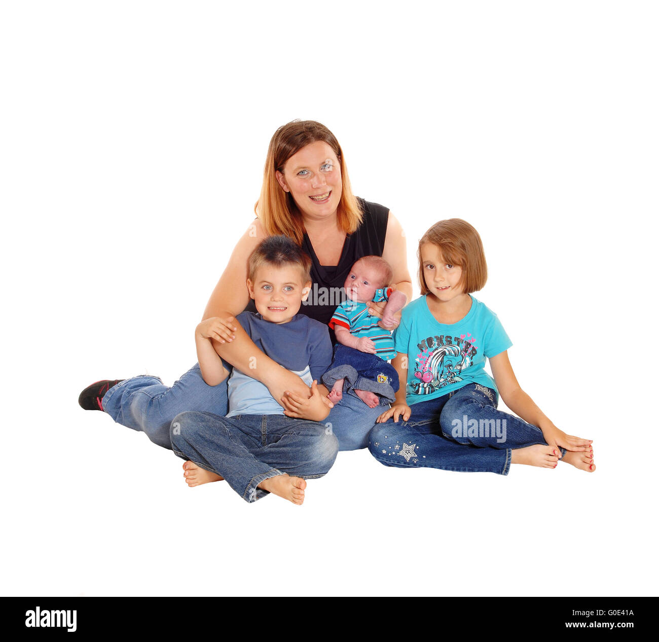 Mother with her three kids sitting on floor. Stock Photo