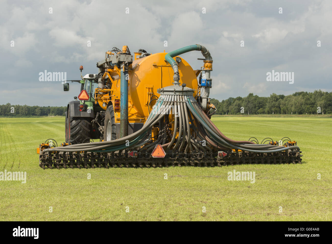 Injecting of liquid manure with tractor and yellow Stock Photo