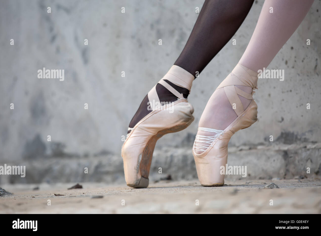 Ballerina feet close-up on a background of textured concrete wal Stock Photo