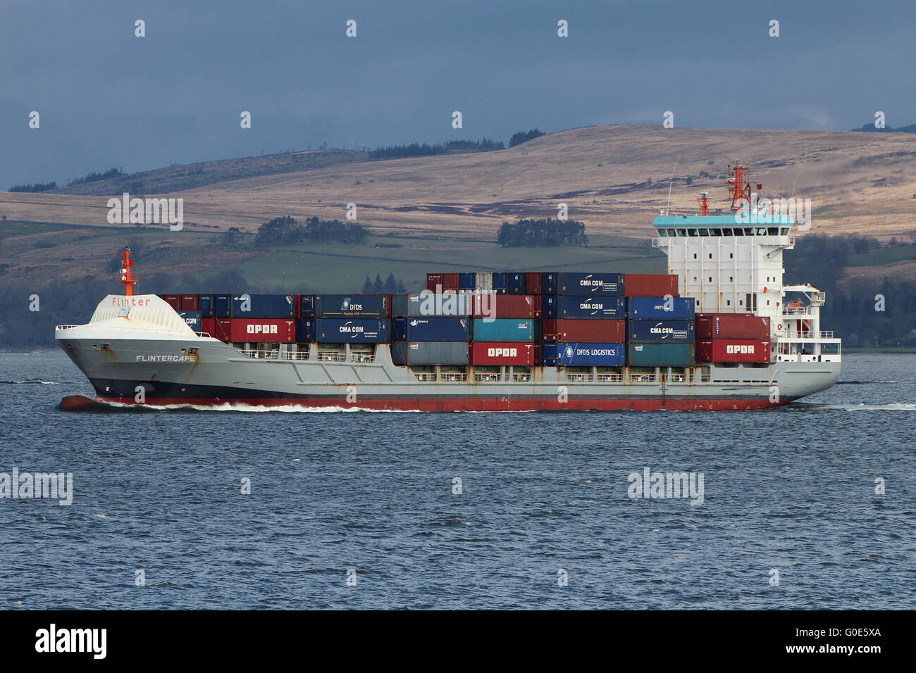 The container ship Flintercape, passing Cloch Point on the Firth of Clyde, on an outbound journey from Greenock. Stock Photo