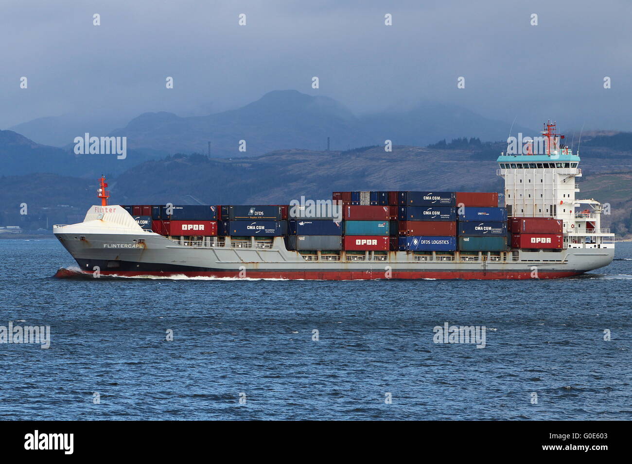 The container ship Flintercape, passing Cloch Point on the Firth of Clyde, on an outbound journey from Greenock. Stock Photo