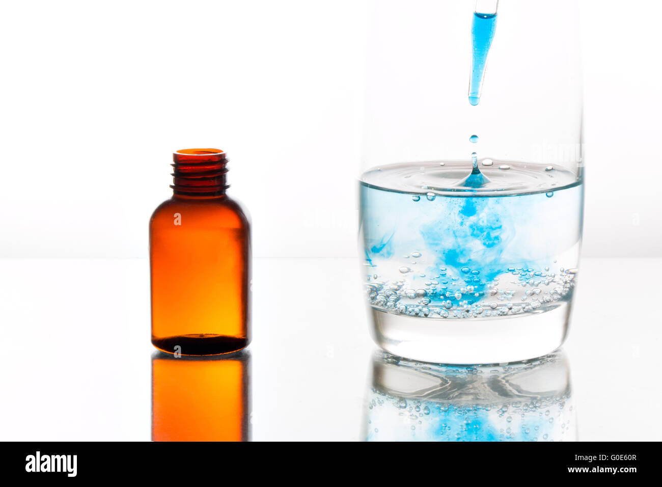 Medicine dropping into a glass of water Stock Photo Alamy
