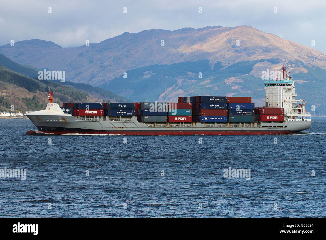 The container ship Flintercape, passing Cloch Point on the Firth of Clyde, on an outbound journey from Greenock. Stock Photo