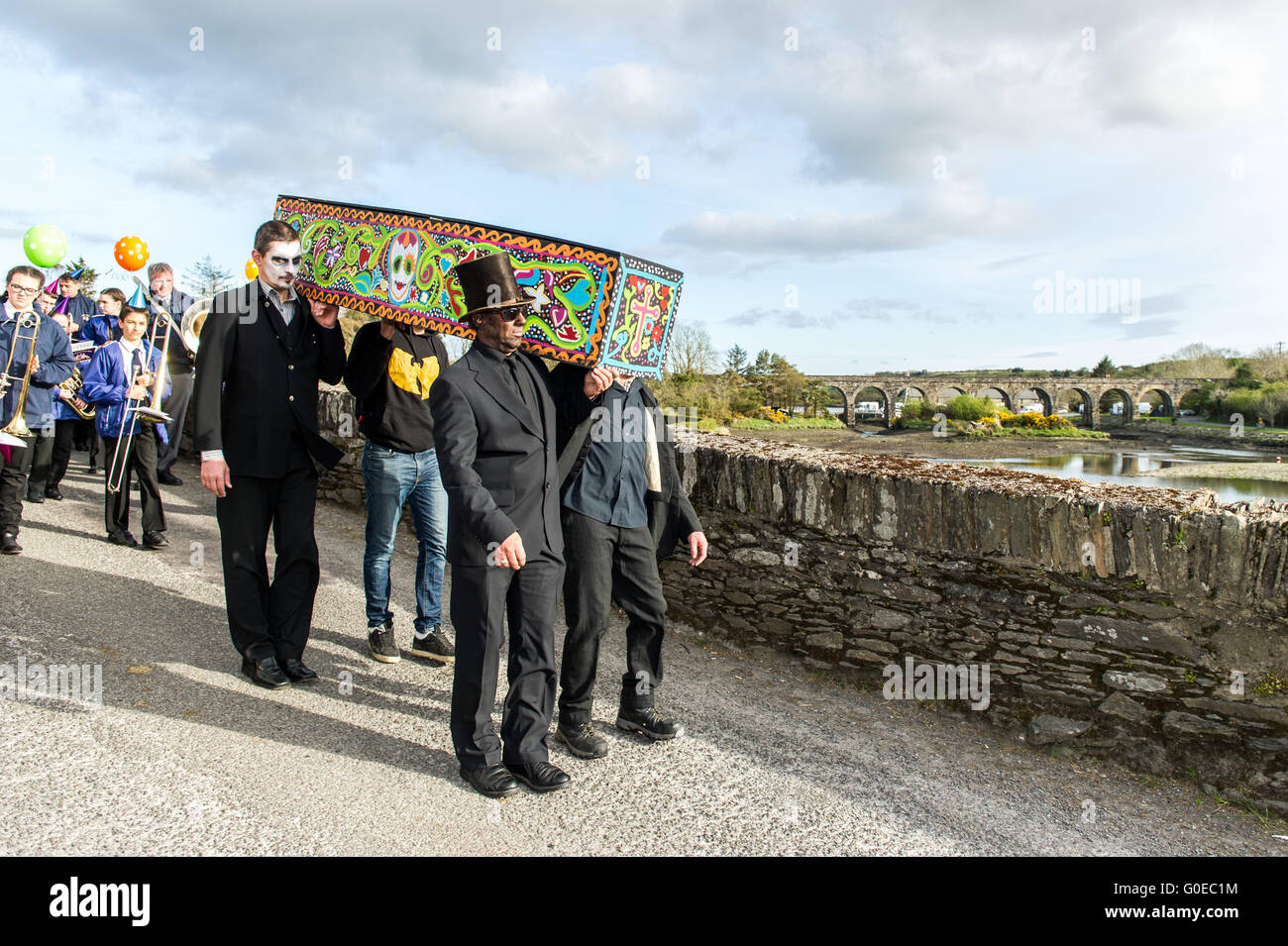 Ballydehob, Ireland. 30th April 2016. With the 12 Arch Bridge in the background, the coffin is carried across Ballydehob bridge during the Ballydehob Jazz Festival 'Day of the Dead' themed New Orleans Style Jazz Funeral. Credit: Andy Gibson/Alamy Live News Stock Photo