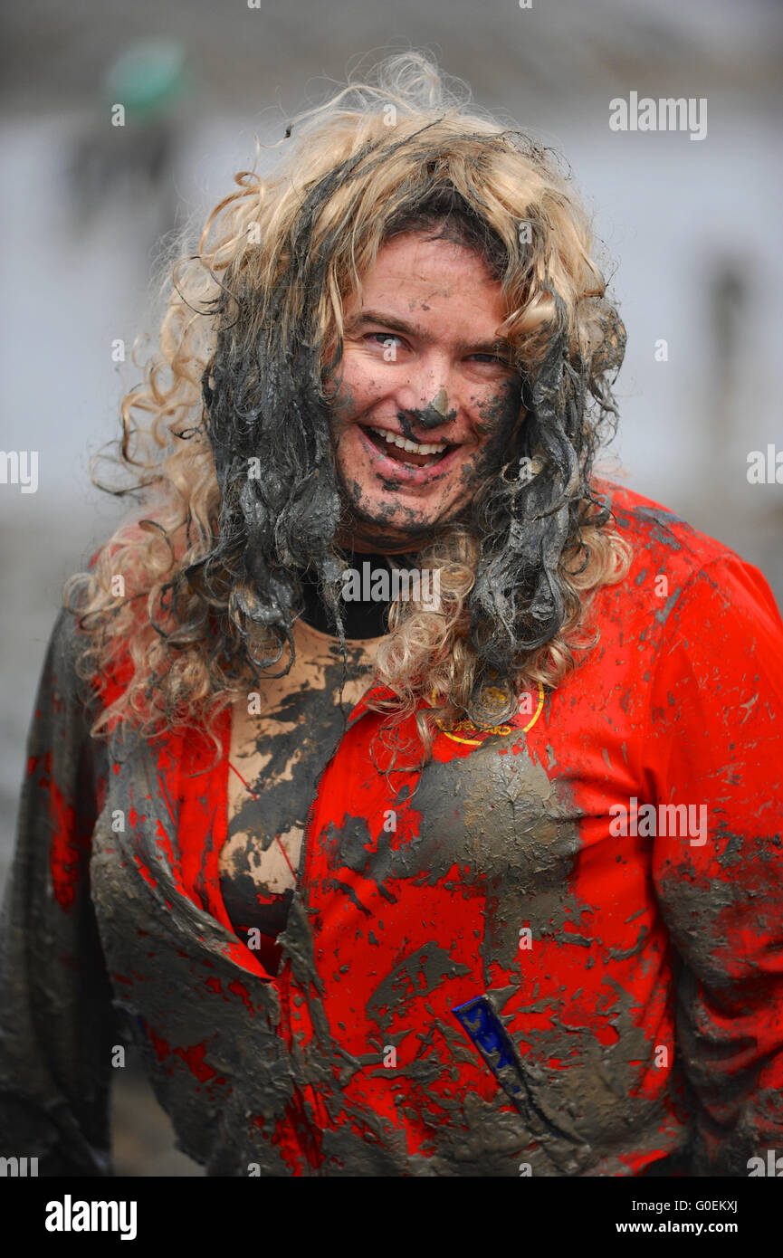 Maldon, Essex, UK. 1st May, 2016. A competitor, wearing a blond wig and falsies, at the finish line of the annual Maldon Mud Race in Maldon, east England. Originated in 1973, the race involves competitors racing around a course through the River Blackwater in Essex at low tide. Credit:  Michael Preston/Alamy Live News Stock Photo