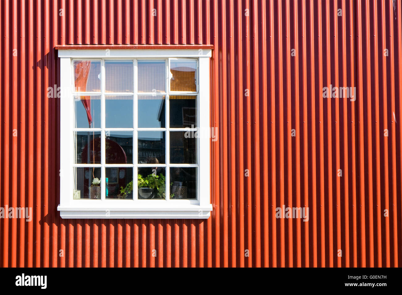 Red wall made of corrugated iron and a white windo Stock Photo