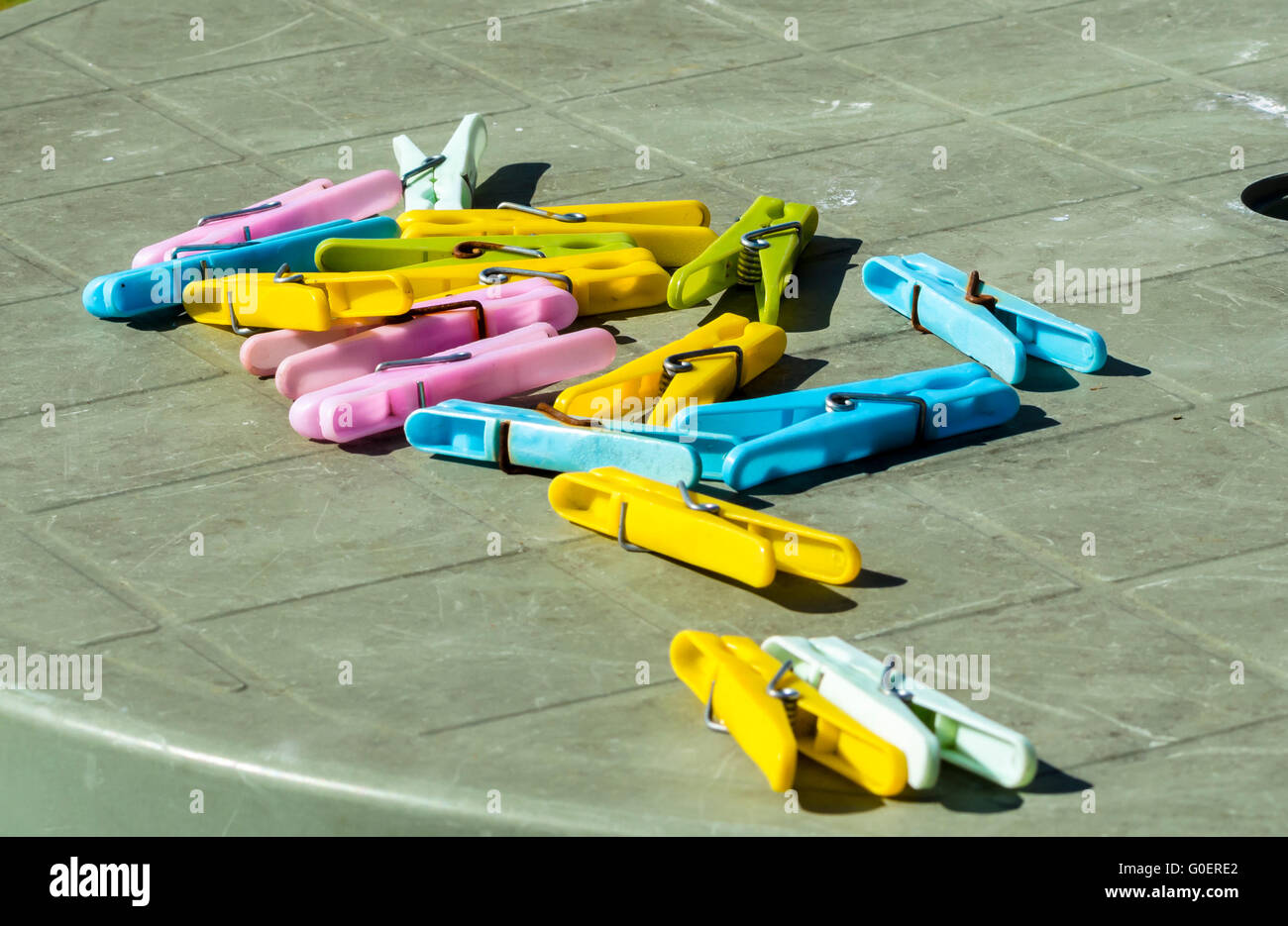 Plastic clothes pegs on an outdoor patio table. Stock Photo