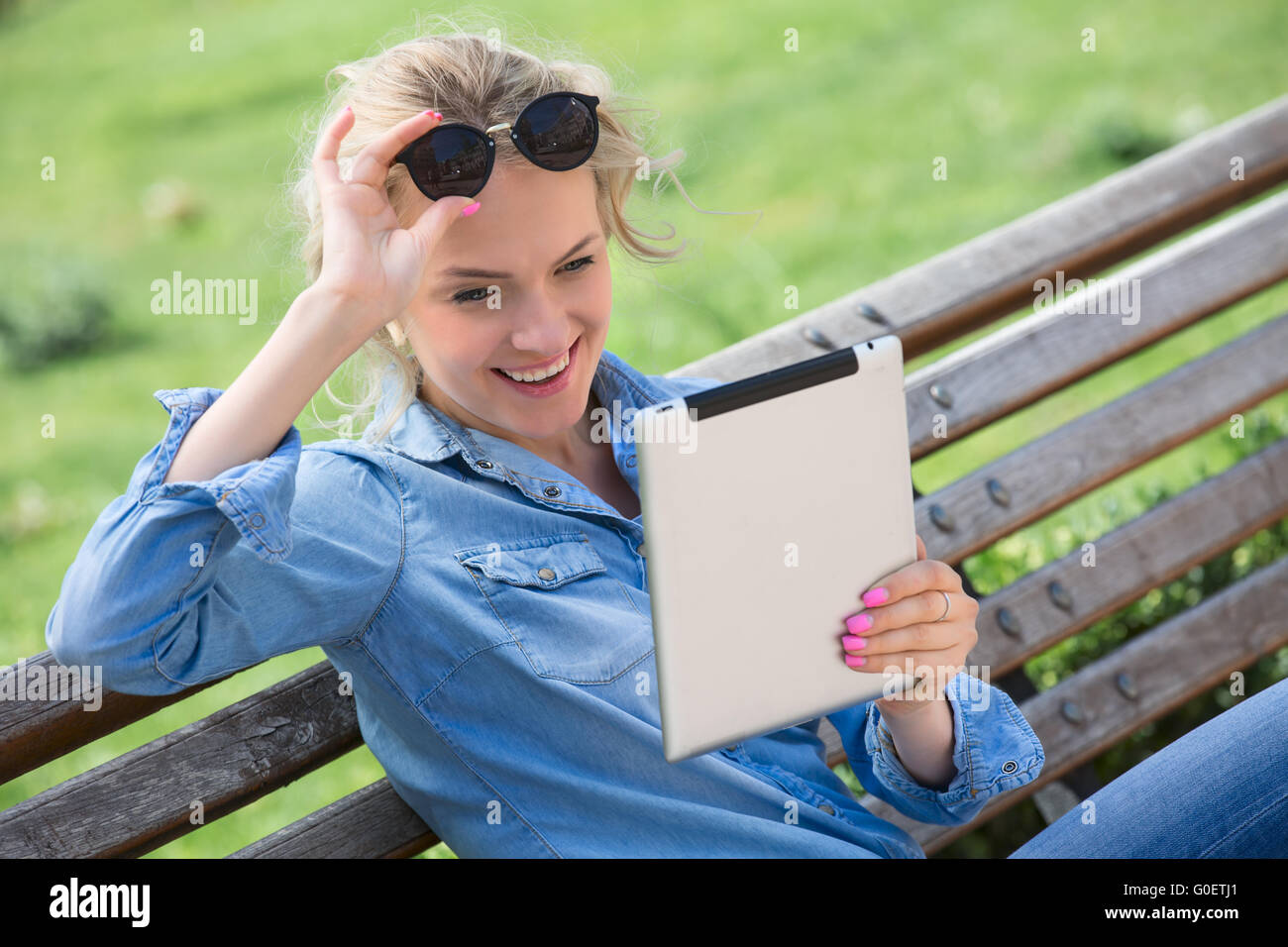 Lovely blond woman with electronic tablet in hands Stock Photo