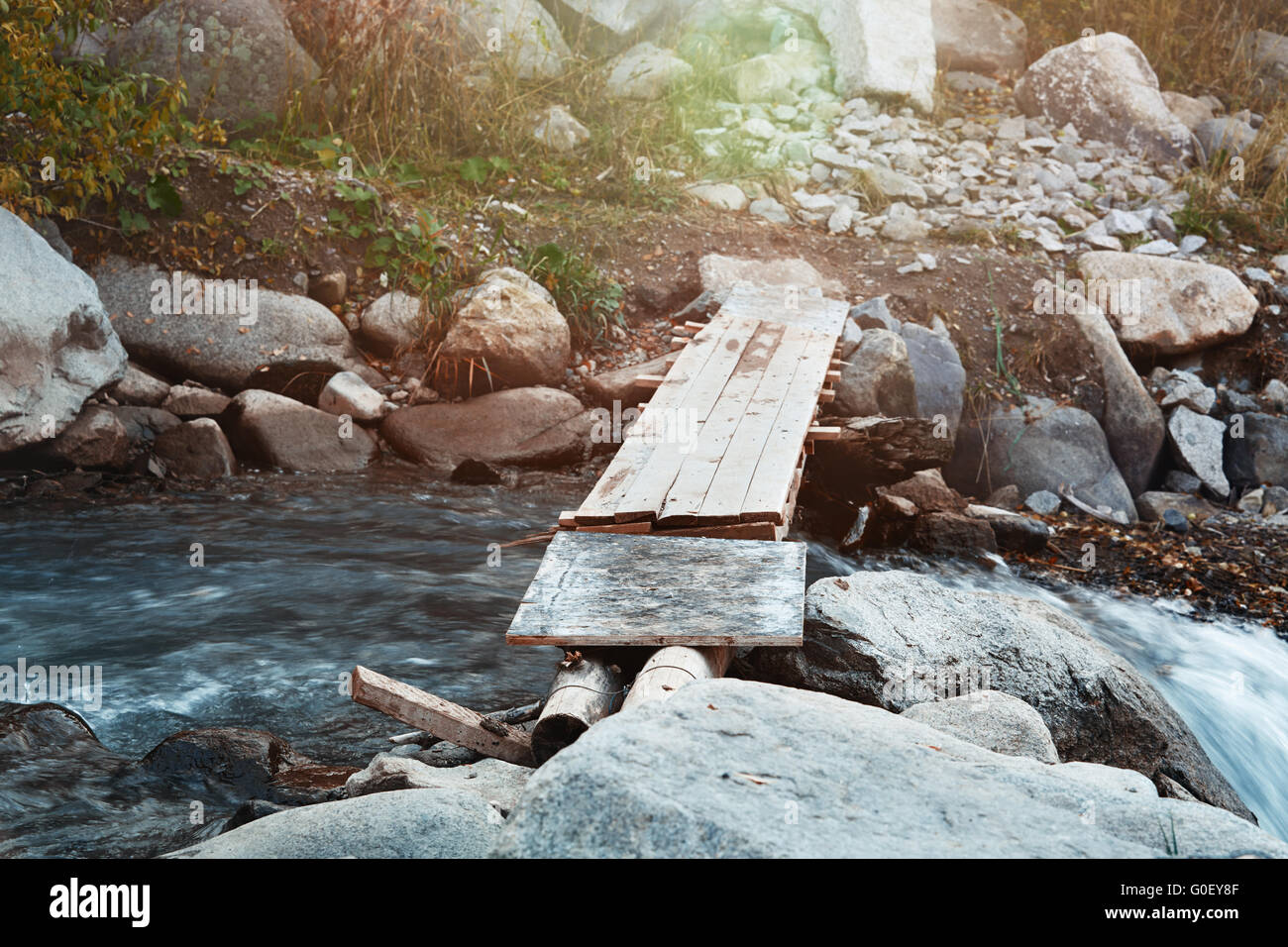 Wooden bridge over small river Stock Photo - Alamy