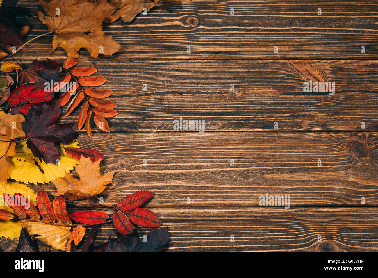 Background with wooden table and autumnal leaves Stock Photo - Alamy