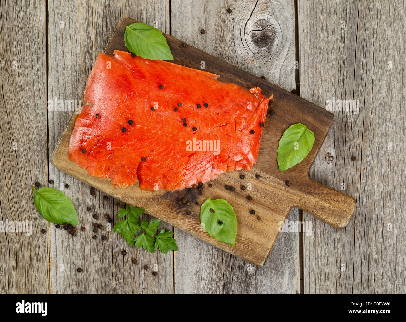 Cold smoke red salmon being prepared on wooden server board Stock Photo