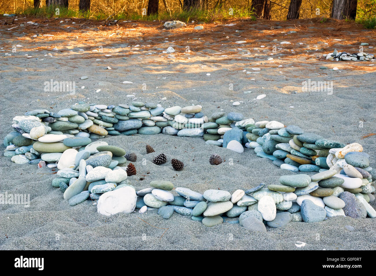 Sea stones on the beach and pine cones. Stock Photo