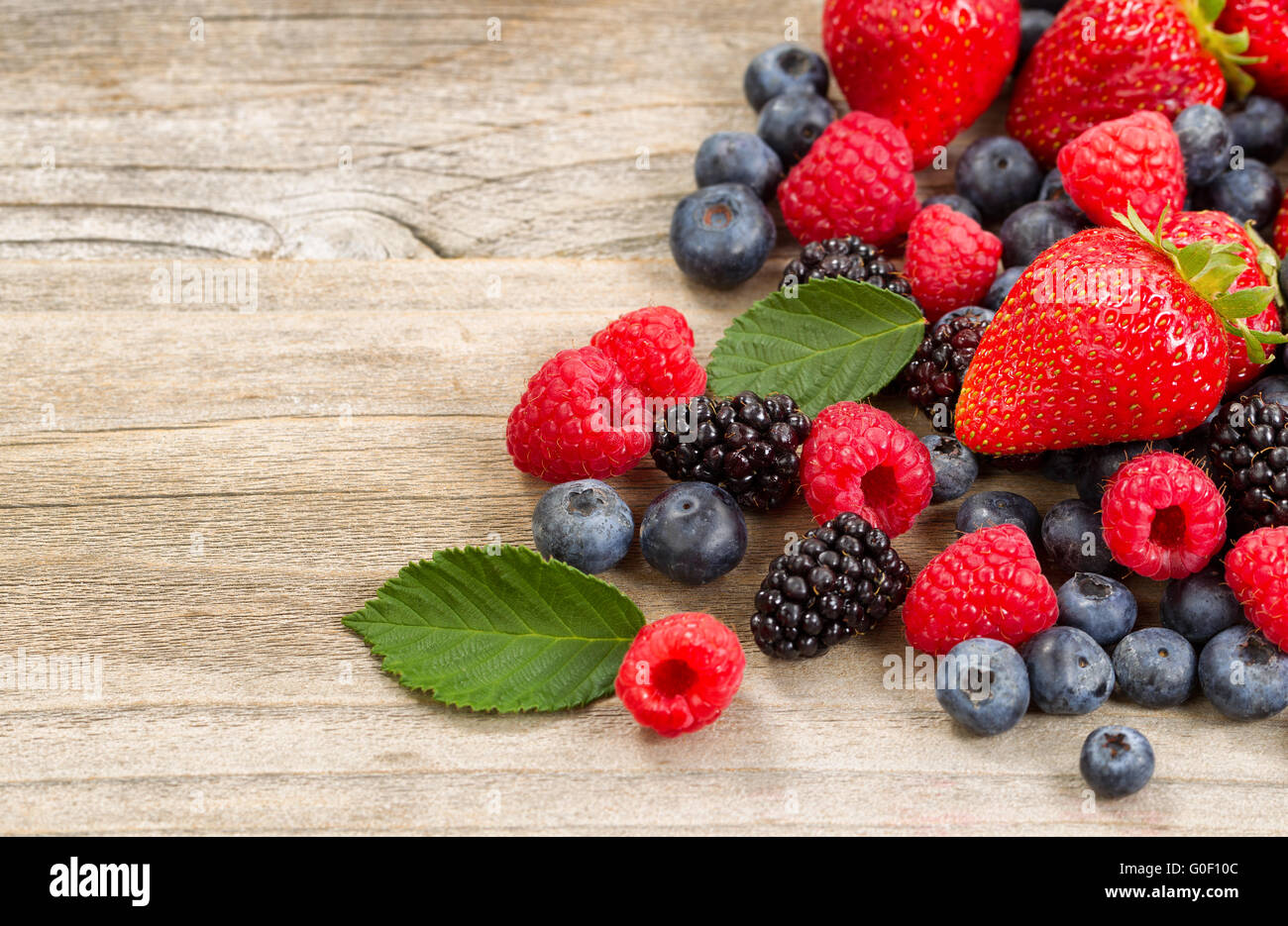 Freshly picked berries on rustic wooden boards Stock Photo