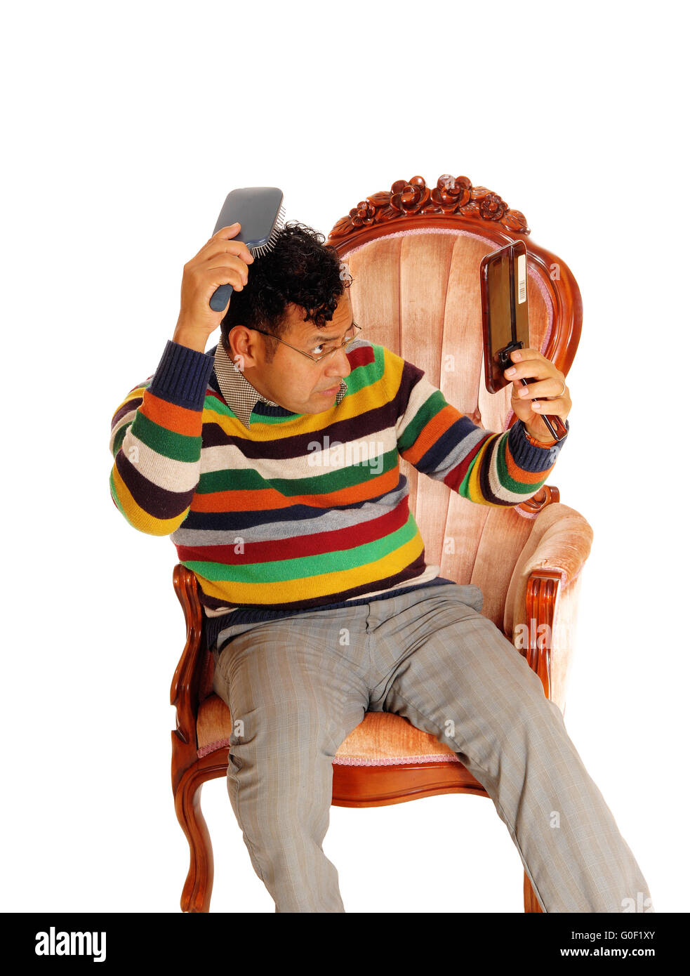 Hispanic man coming his hair. Stock Photo