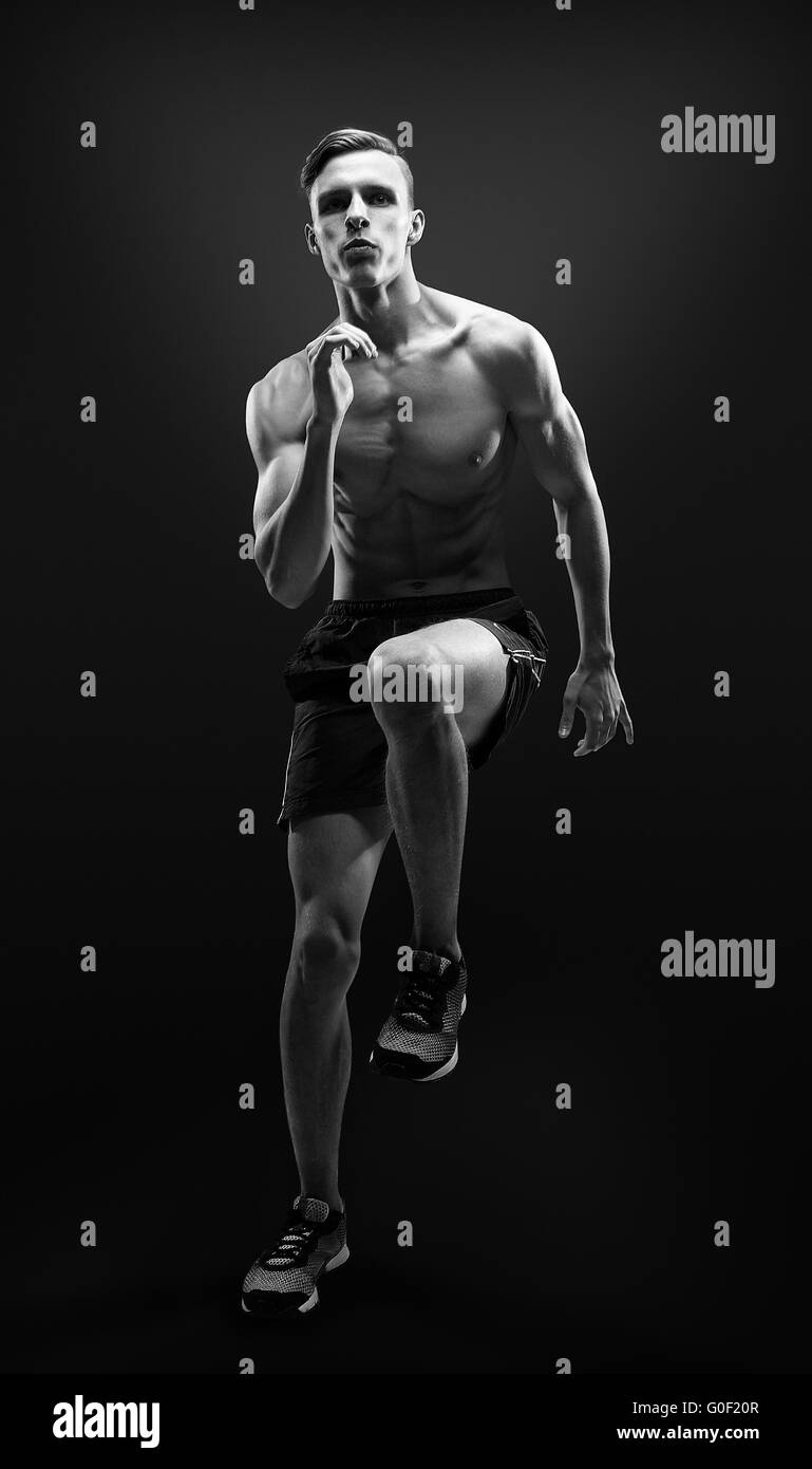 Healthy and fitness man running on black background. Stock Photo