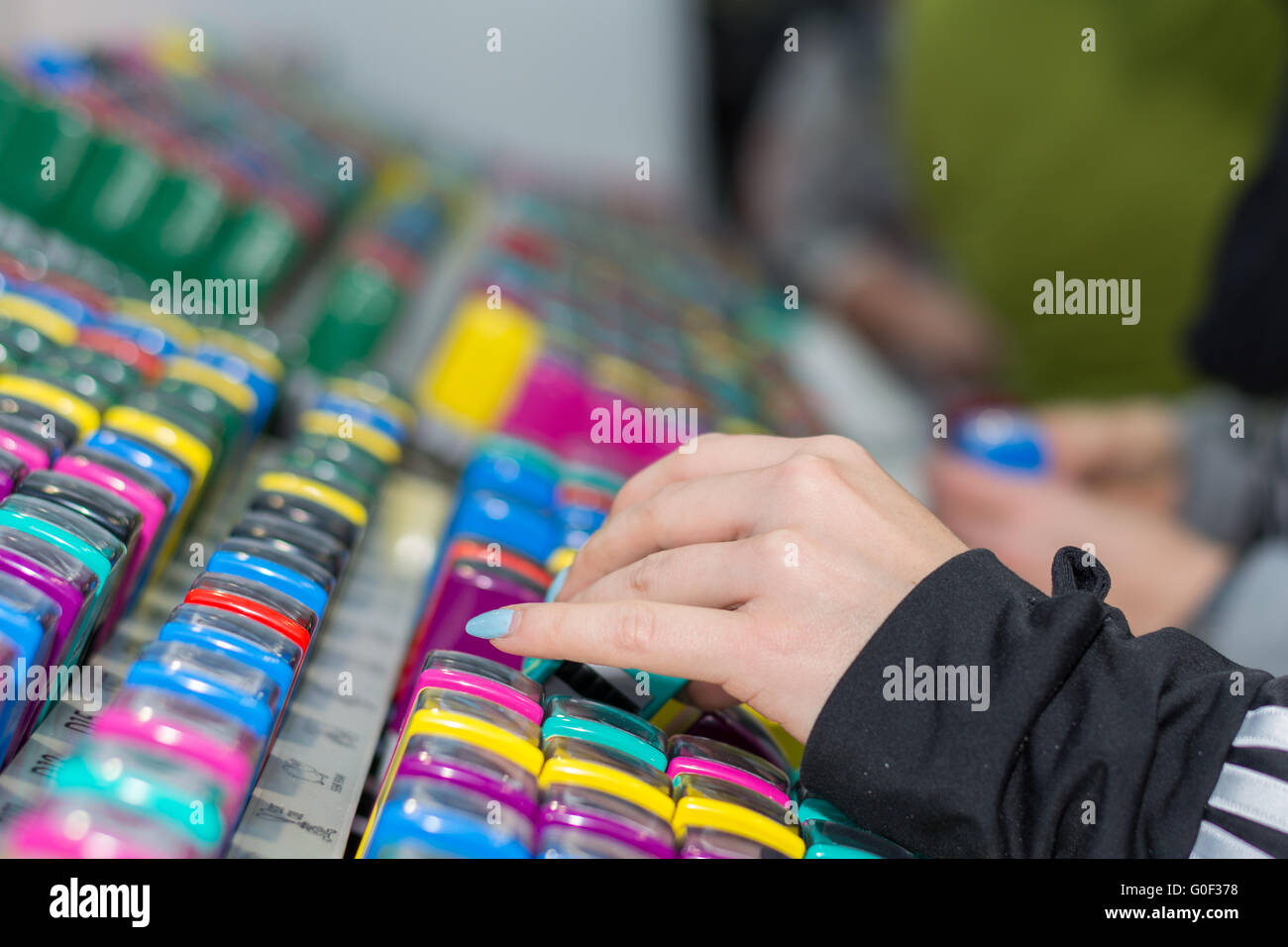 Person with painted nails examined in colorful children's stamped Stock Photo