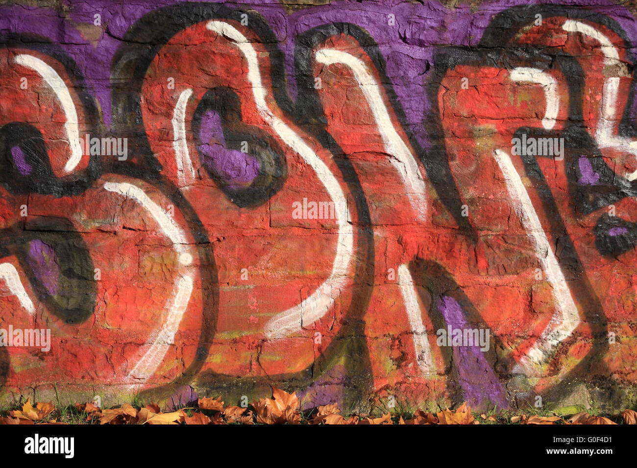Graffiti in front of autumn leaves Stock Photo
