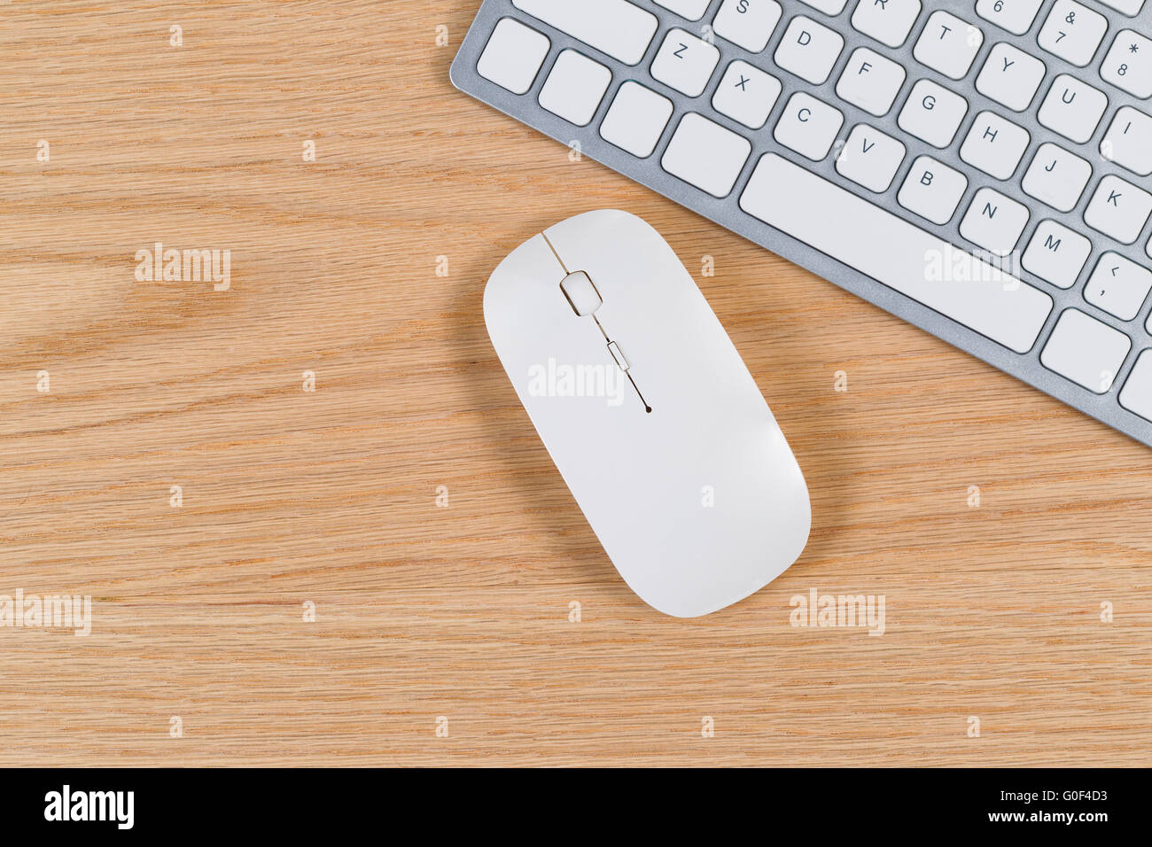 Clean desktop with keyboard and mouse on red oak surface Stock Photo