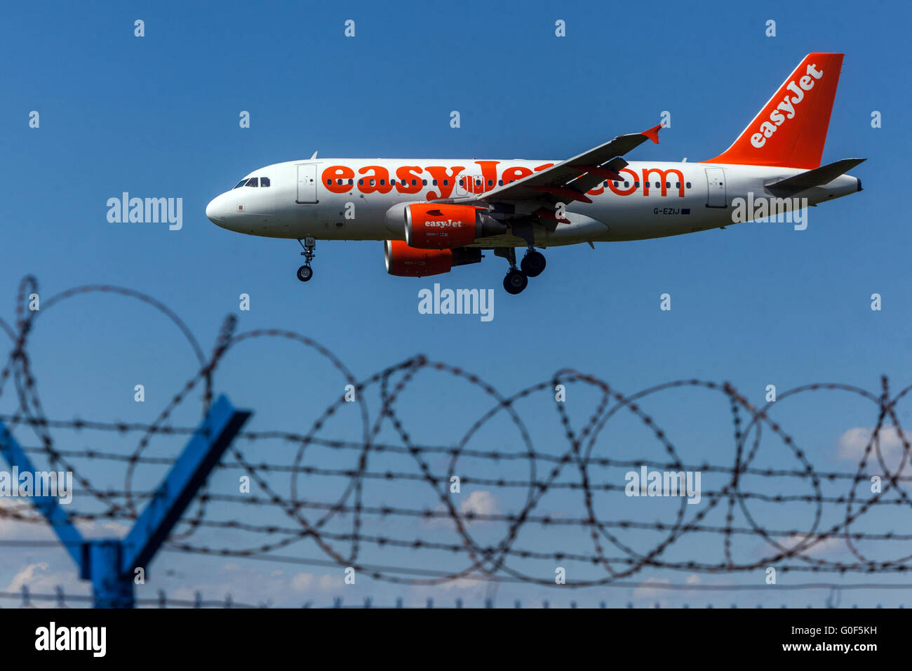 Airbus A319 EasyJet aircraft landing above barbed wire fence Prague, Czech Republic Stock Photo