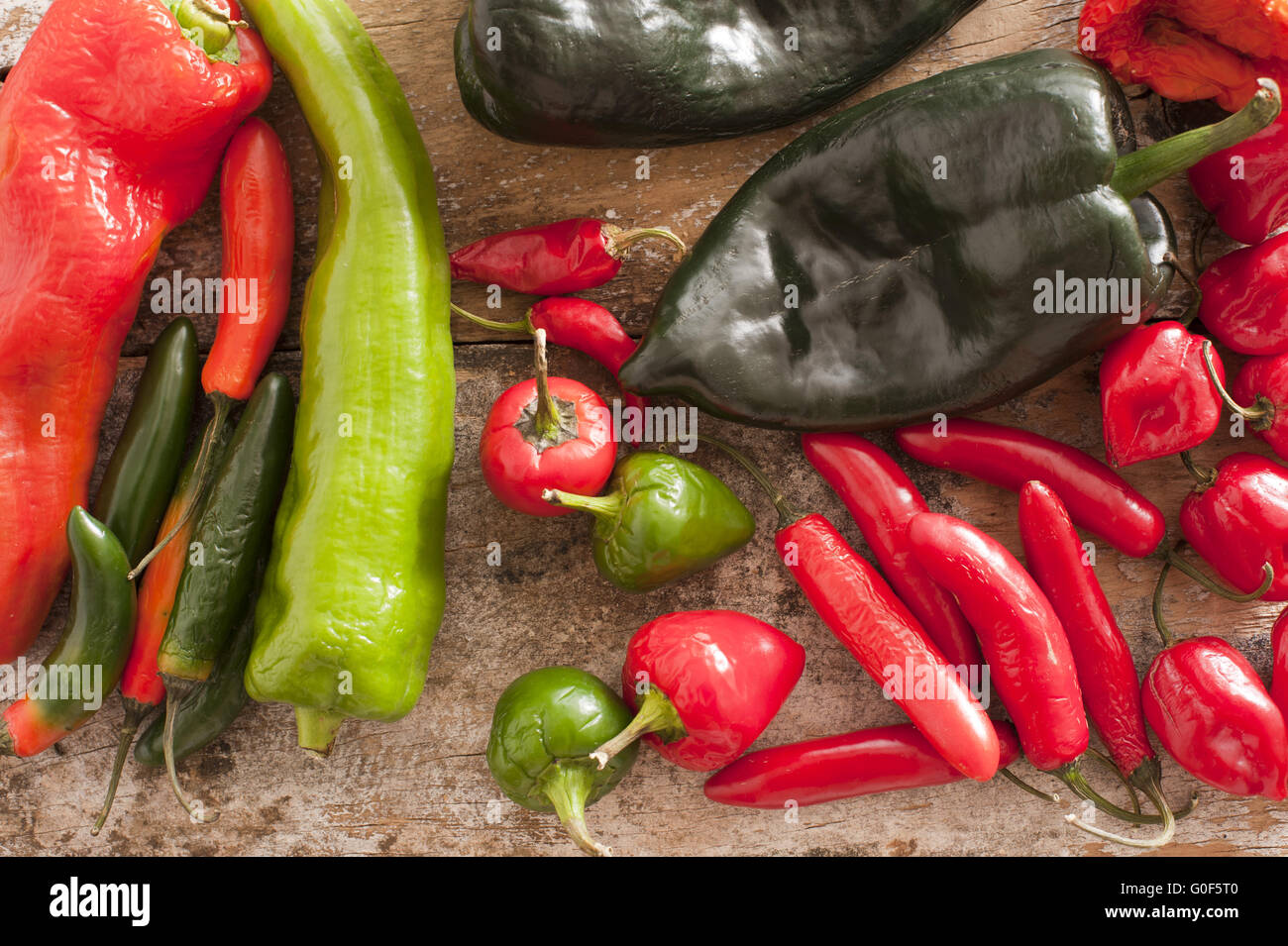 Red and Green Chili Peppers on a Wooden Table Stock Photo