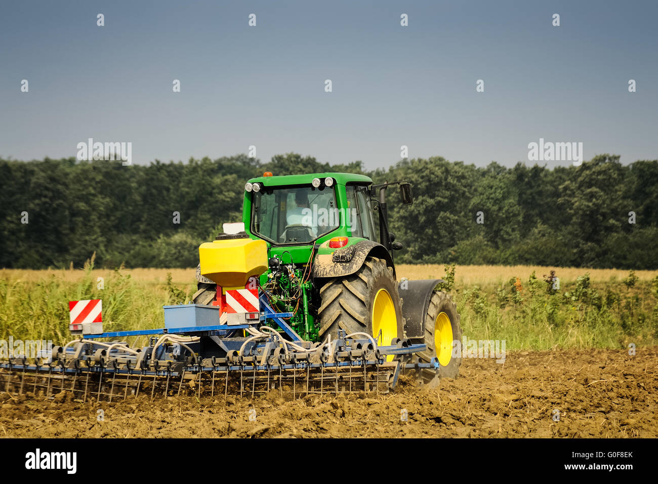 Farmer with Tractor at work Stock Photo