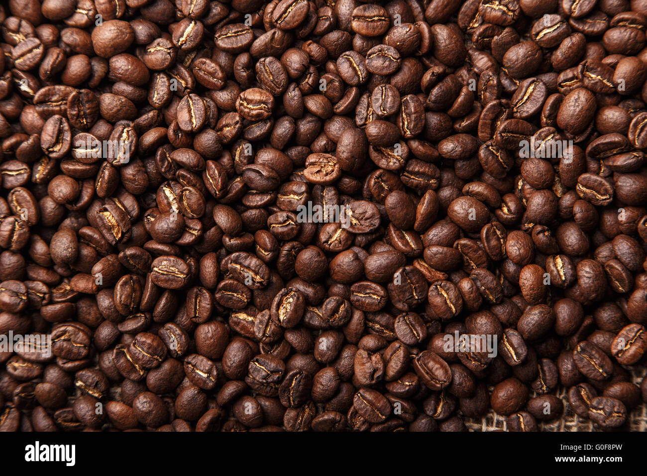Brown coffee beans background closeup Stock Photo - Alamy