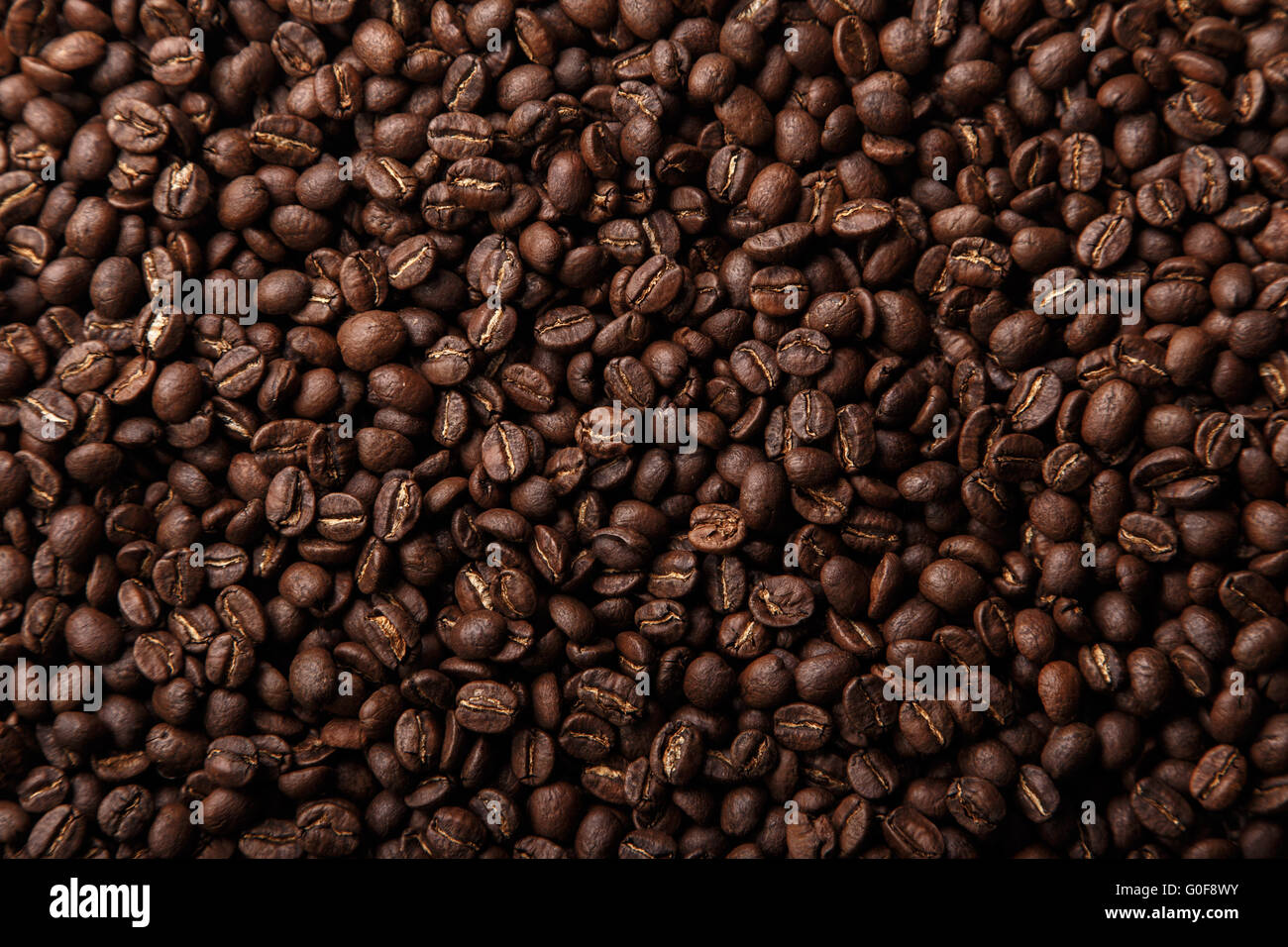 Brown coffee beans background closeup Stock Photo - Alamy