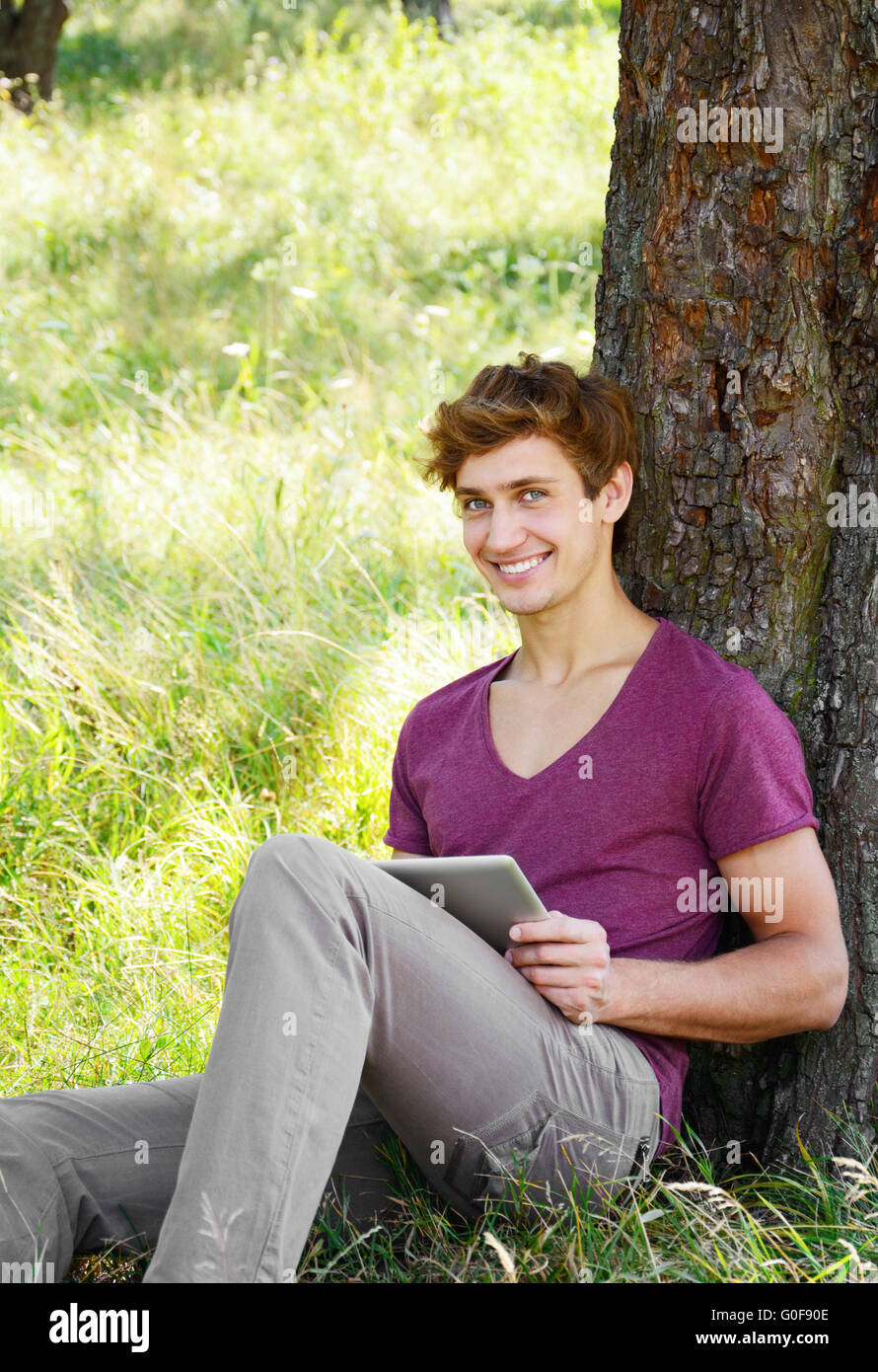 Young Man Using Tablet Young man is using tablet Stock Photo - Alamy