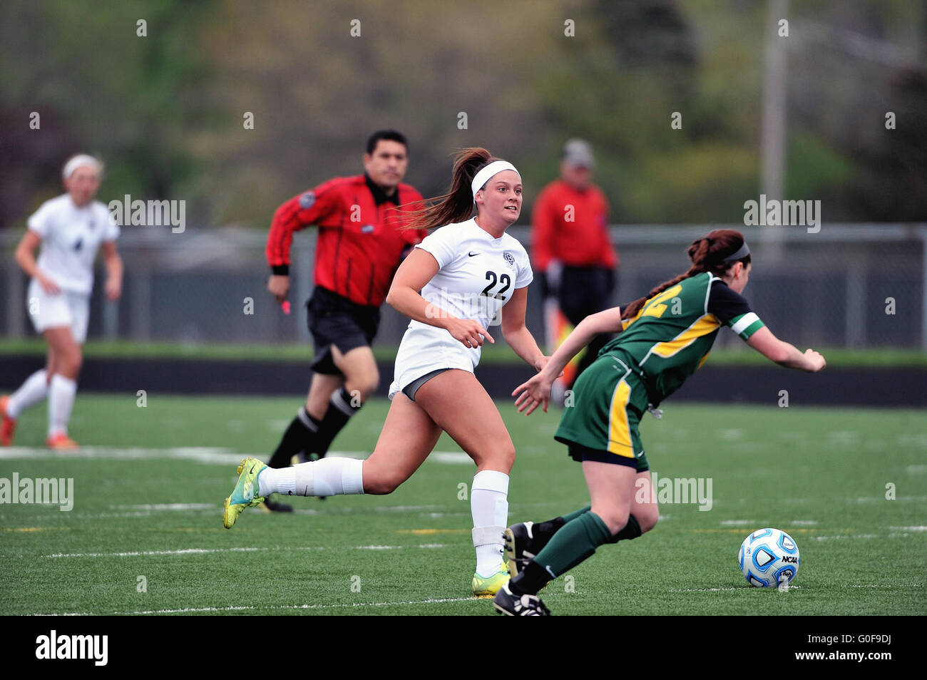 Midfielder dribbling past a defender as she attempts to set up a scoring opportunity for her team during a high school match. USA. Stock Photo