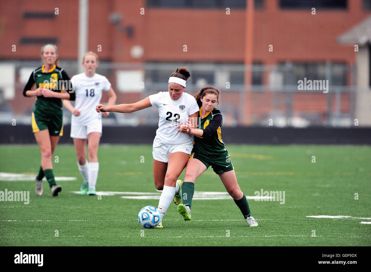 Opposing players battle for control of the all near midfield during a high school soccer match. USA. Stock Photo