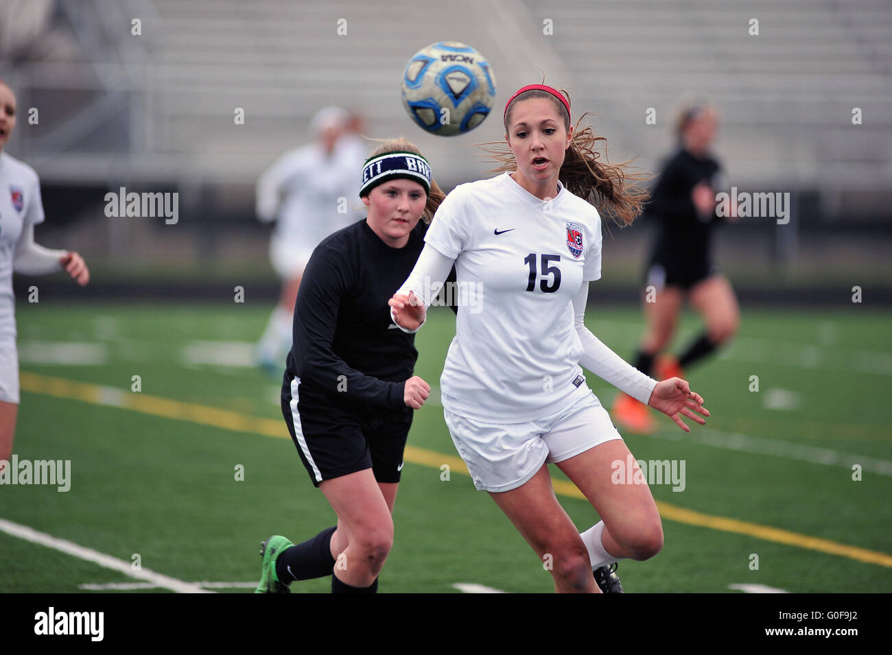 Players battle along the sideline for control of inbounded ball during a high school soccer match. USA. Stock Photo