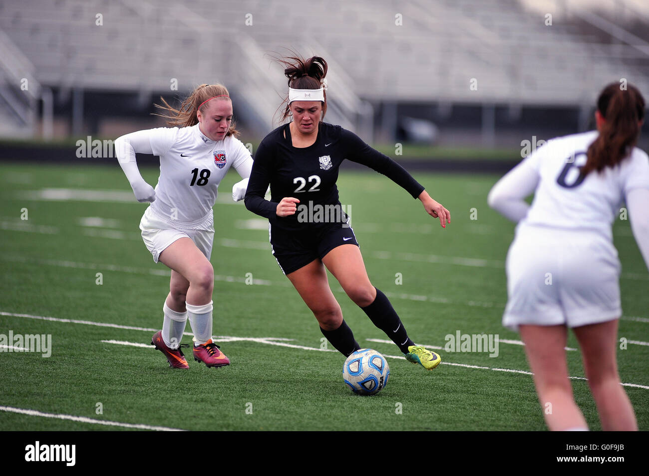 Midfielder dribbling among the opposing defense with while trying to get off a shot on goal during a high school soccer match. USA. Stock Photo