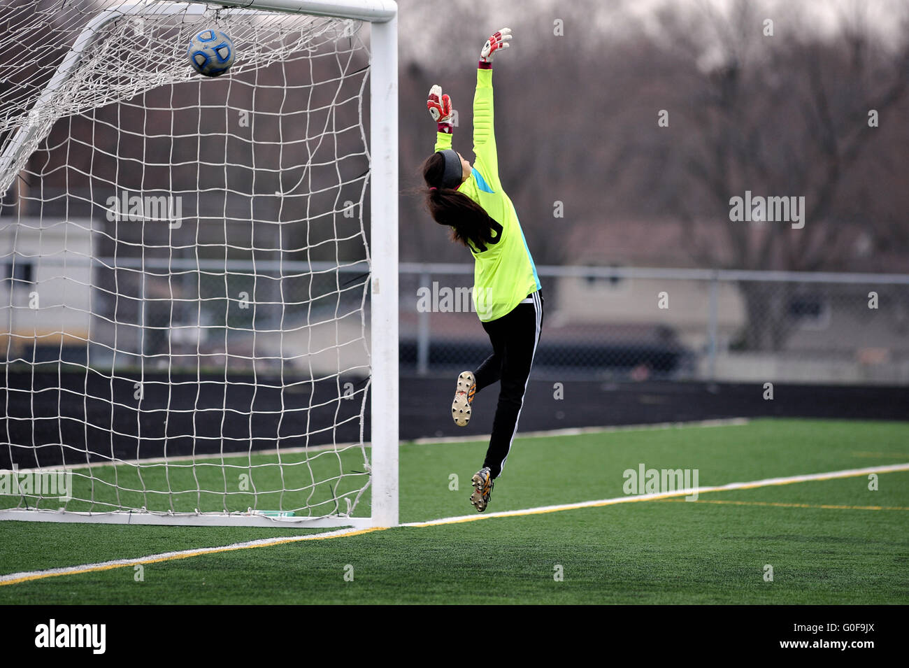 Goal keeper is unable to stop a well placed ball that eluded her leaping effort during a high school soccer match. USA. Stock Photo