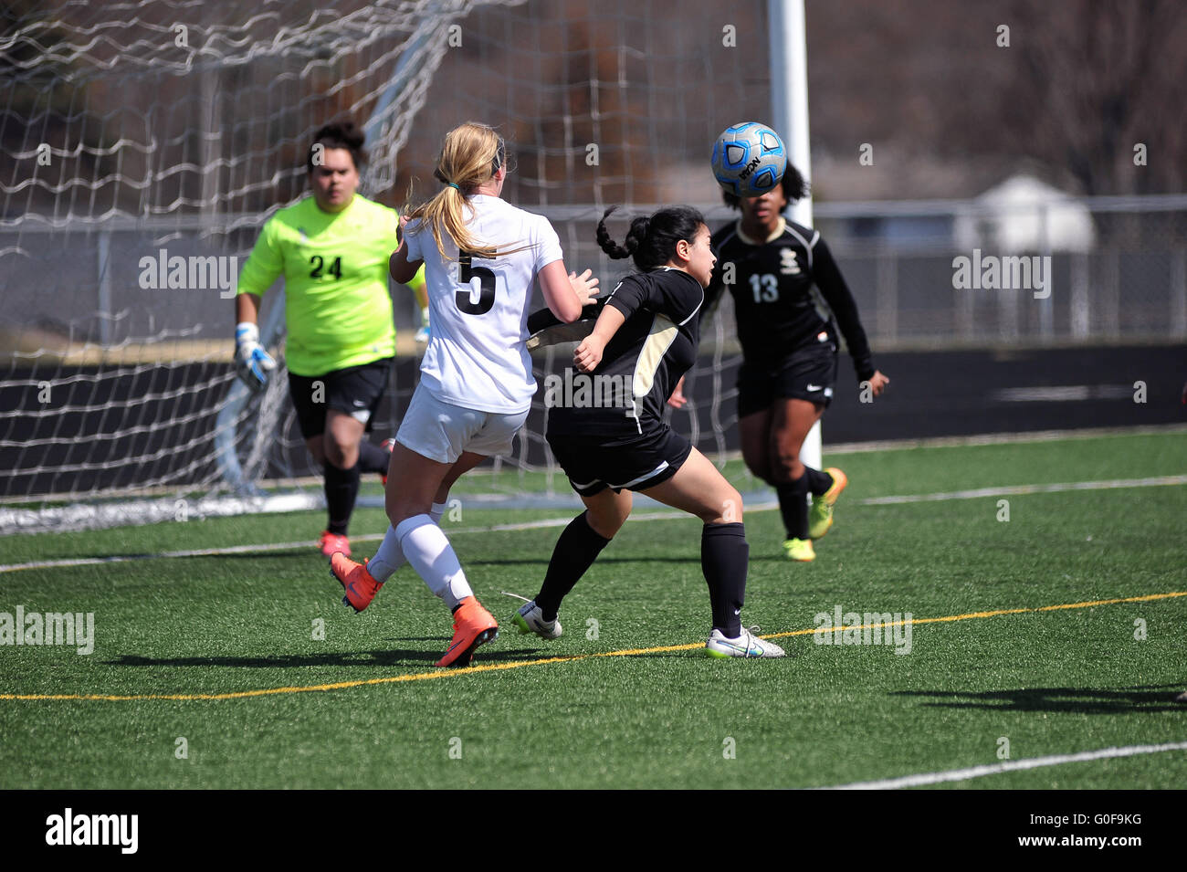 A defender executes a header to clear the ball from in front of her ...