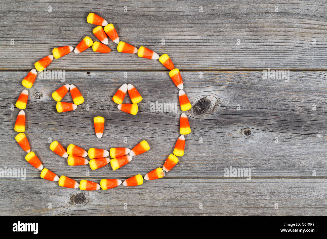 Candy shaped as Halloween Pumpkin on rustic Wood Stock Photo