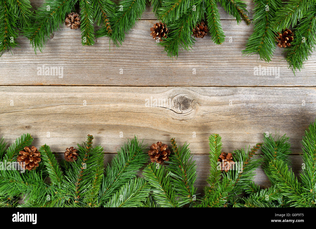 Christmas holiday border with evergreen branches on rustic cedar