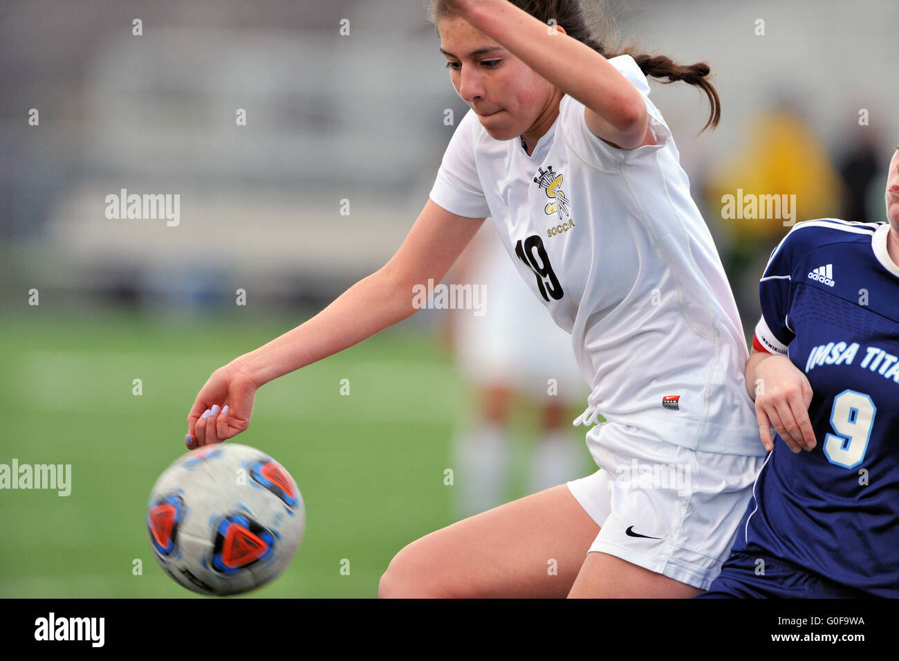 Player blocks out an opponent while attempting to control an inbounded ball during a high school soccer match. USA. Stock Photo