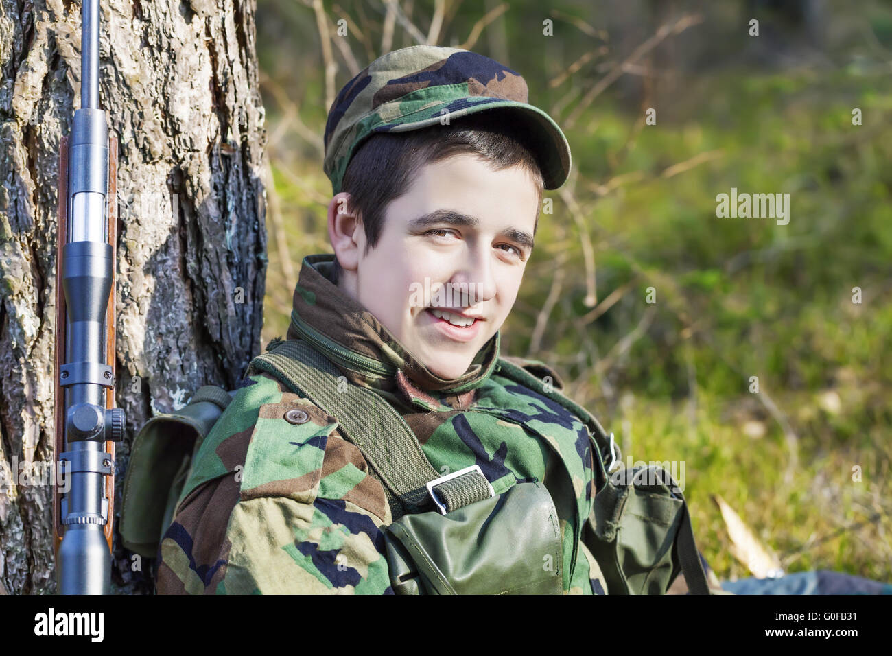 Young recruit with optical rifle in forest Stock Photo