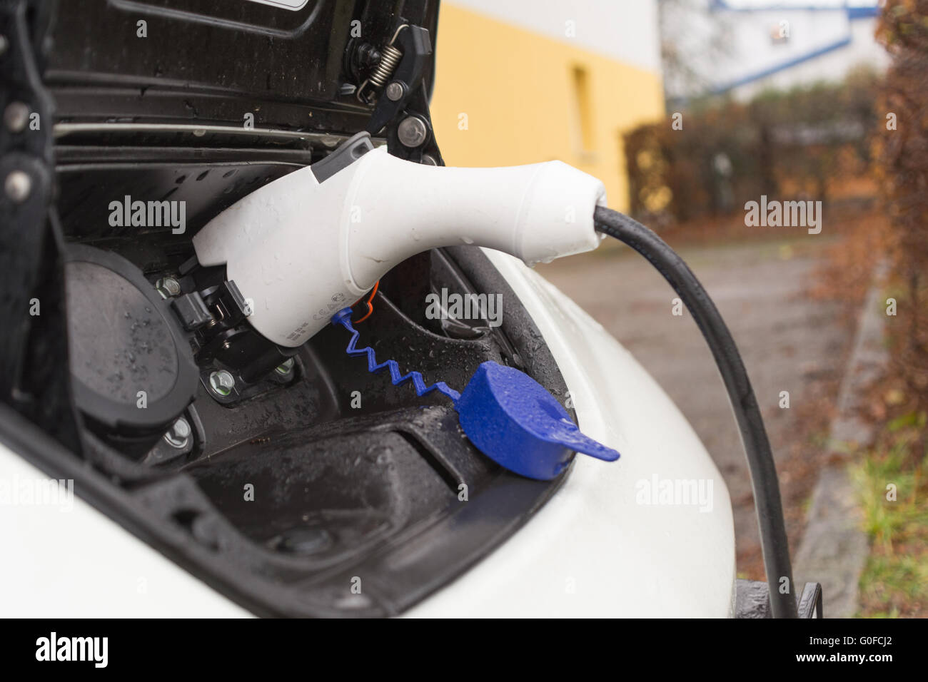 Electric car at the socket - close-up Stock Photo
