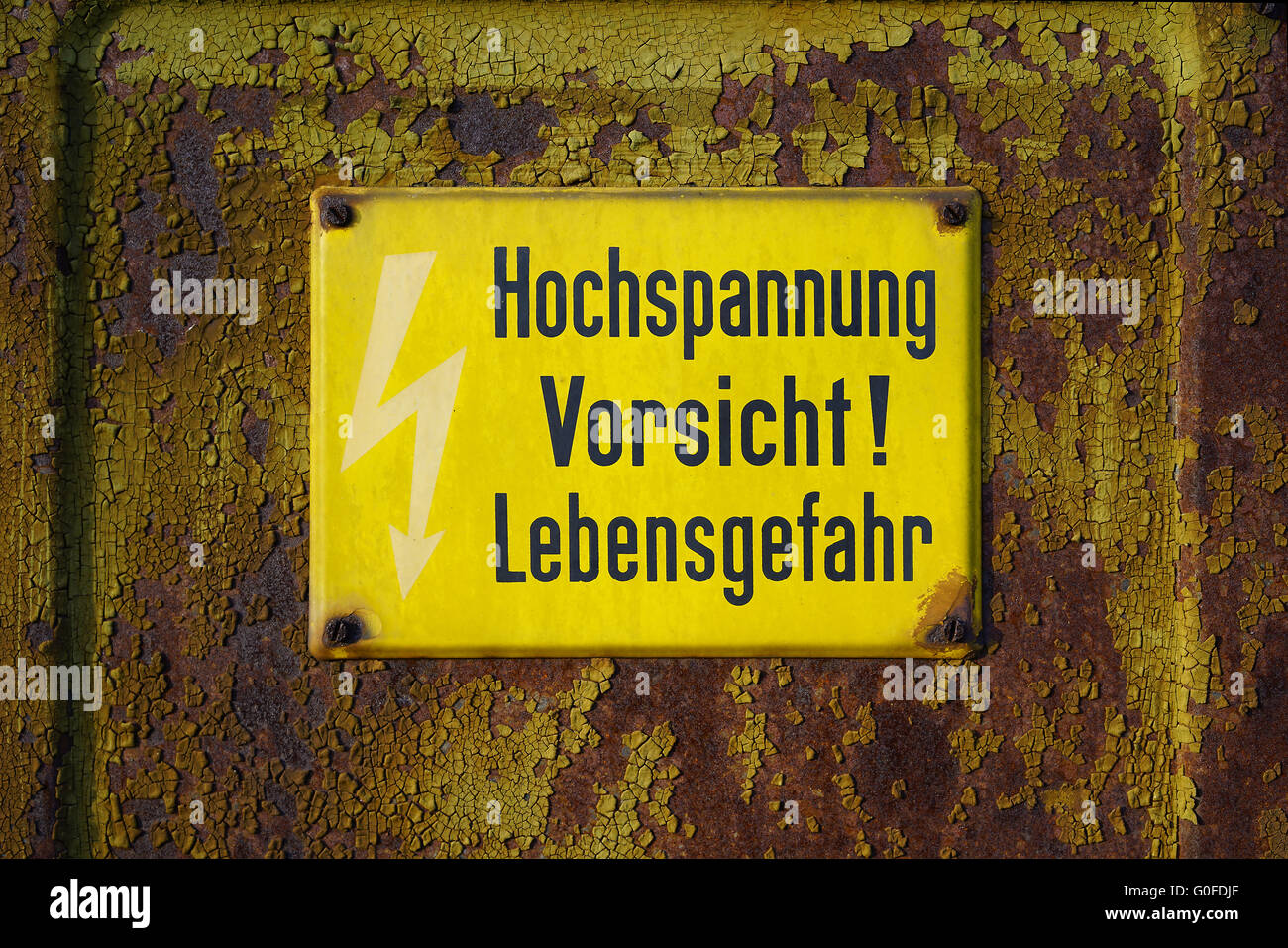 yellow warning sign that says high voltage Caution mortal danger Stock Photo