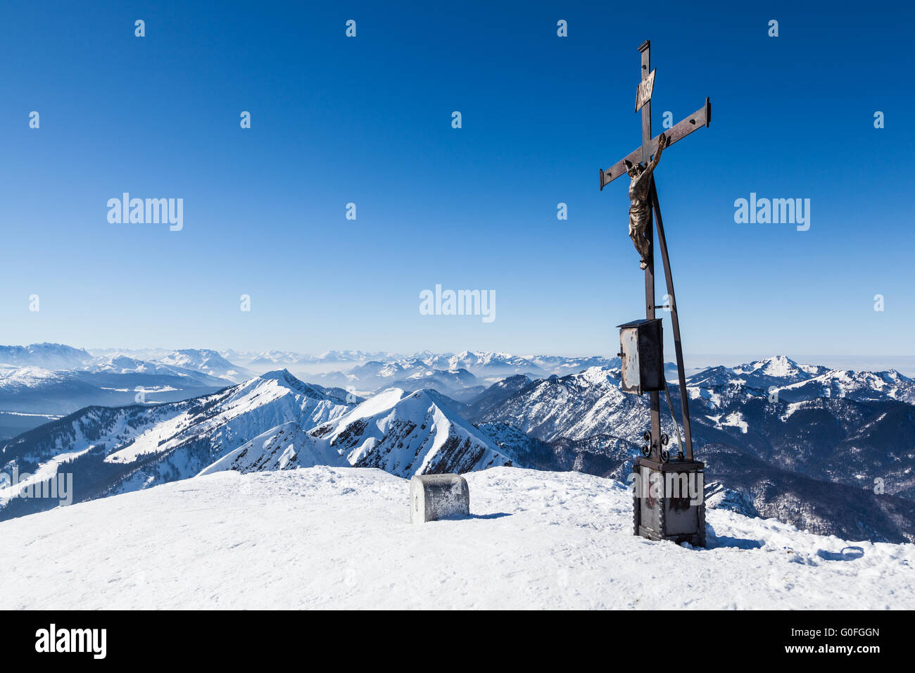 winterly summit cross with mountain range Stock Photo