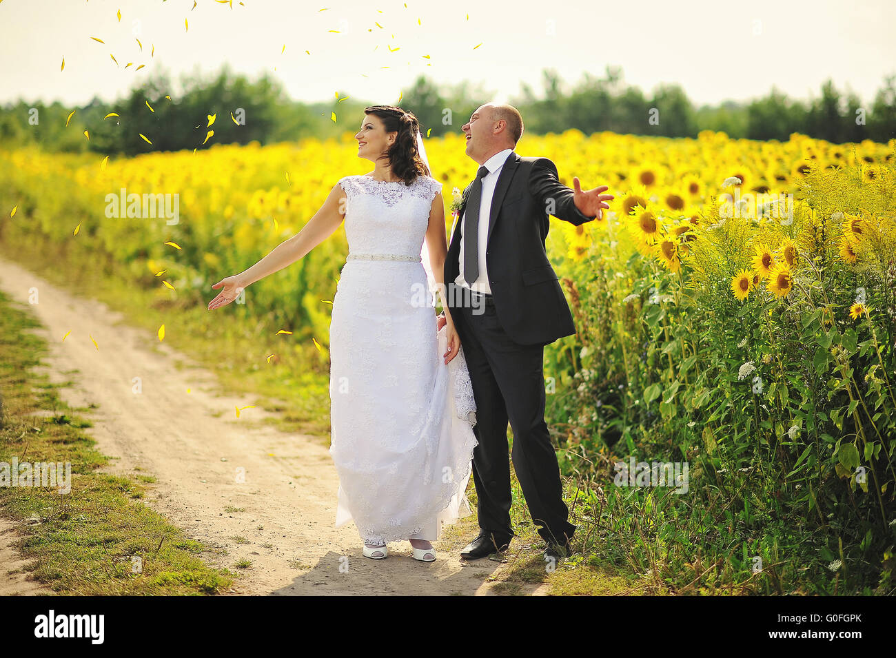 Happy marriage couple at the field of sunflowers Stock Photo