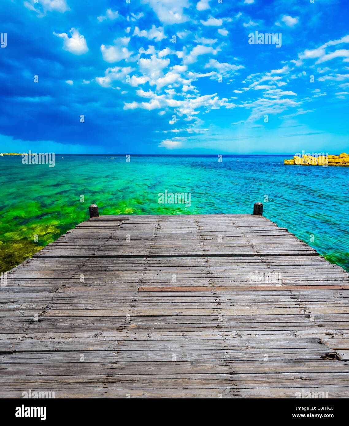 wooden batten bridge juts out into the expanse of the sea Stock Photo