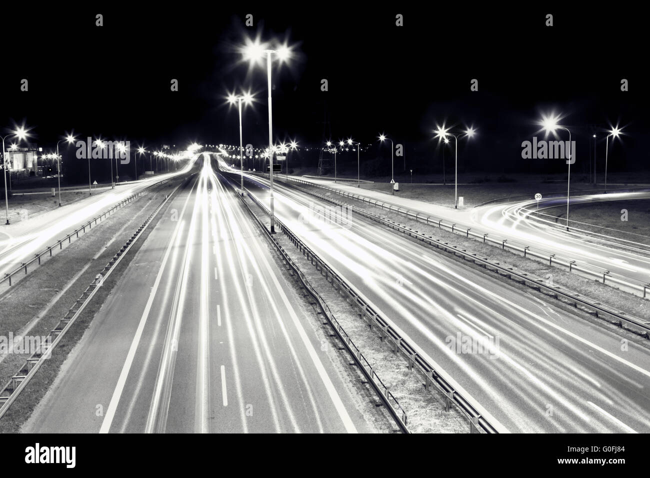 Highway traffic at night. Cars lights in motion on the streets. Transport Stock Photo