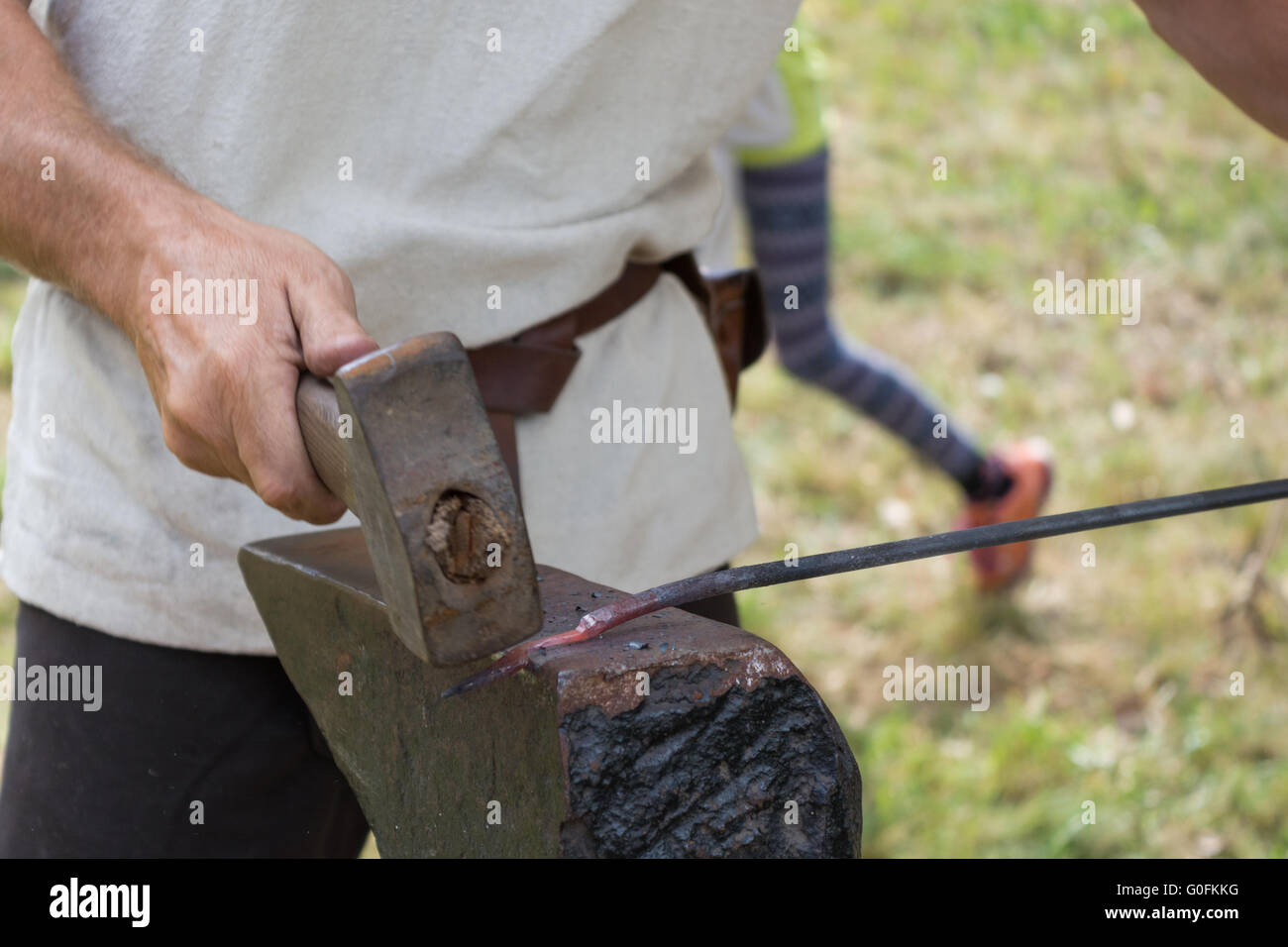 Blacksmith shaping metal on anvil Stock Photo