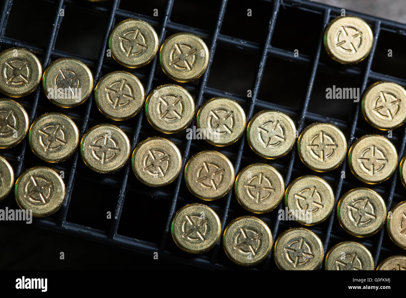 Scattering of small caliber cartridges on a wooden background Stock Photo